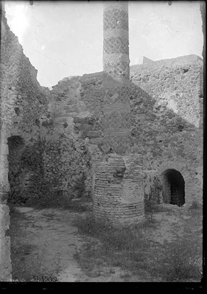 VII.5.10 Pompeii. 1931. Courtyard (33) with column (34), staircase (35) to caldarium, and entrance (36) to praefurnium (boiler) area.
DAIR 31.2528. Photo � Deutsches Arch�ologisches Institut, Abteilung Rom, Arkiv. 
The courtyard is accessible off Vicolo delle Terme.
On the left is the entrance corridor (32) to the praefurnium.
The ramped masonry staircase (35) allows access to the roof of the caldarium.
The circular brick base had a column (34) erected on it after the earthquake, probably to support a sundial.
The smaller arch on the right is entrance (36) to praefurnium (boiler) area.
See Carratelli, G. P. ed., 1990-2003. Pompei: Pitture e Mosaici. Vol. VII. Roma: Istituto della enciclopedia italiana, p. 172. 

Alternative sources, such as Niccolini, have suggested the column is a roof support.


