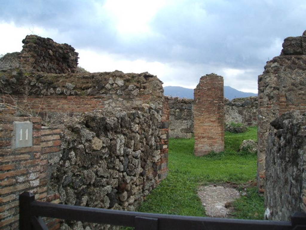 VII.6.11 Pompeii. December 2004. Looking south along entrance corridor towards site of atrium. This area was affected by the bombing in September 1943.  A photograph of the area can be seen showing the same brick pilaster, about the only thing left standing in the area. See Garcia y Garcia, L., 2006. Danni di guerra a Pompei. Rome: L�Erma di Bretschneider. (p.104, Fig 233 (Foto SAP neg. no.176)
