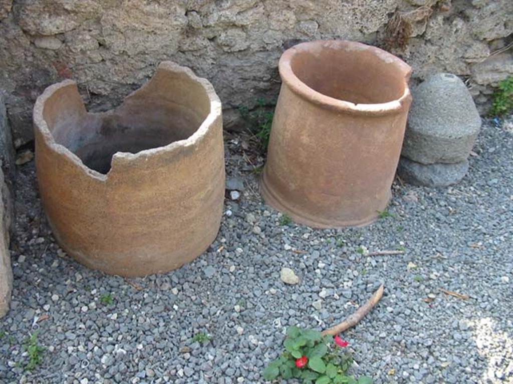 VII.6.21 Pompeii. May 2003. Remains of terracotta pots and small millstone. Photo courtesy of Nicolas Monteix.