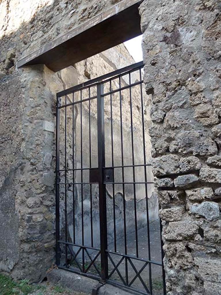 VII.6.38 Pompeii. June 2012. Looking towards remains of painted decoration on north side of entrance corridor. The holes for the beam supports for the floor of the upper room can be seen in the north wall. The north wall was more complete than the south wall. The zoccolo was black, and above it were black panels, separated by thin red bands, and the upper part of the wall was white.

