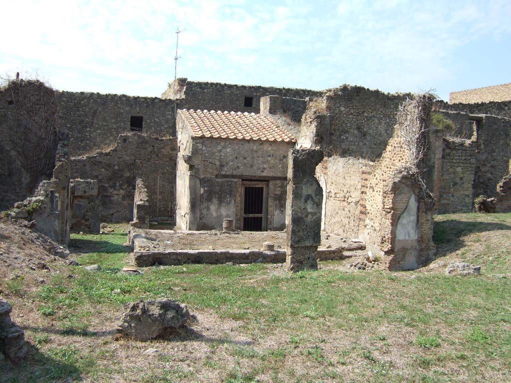 VII.6.38 Pompeii. September 2005. Looking west from VII.6.28 across site of oecus or tablinum, across garden area to entrance.
On the left in the centre of the photo is the doorway to room 28, on its left would have been corridor 30 leading left to other small service rooms.
