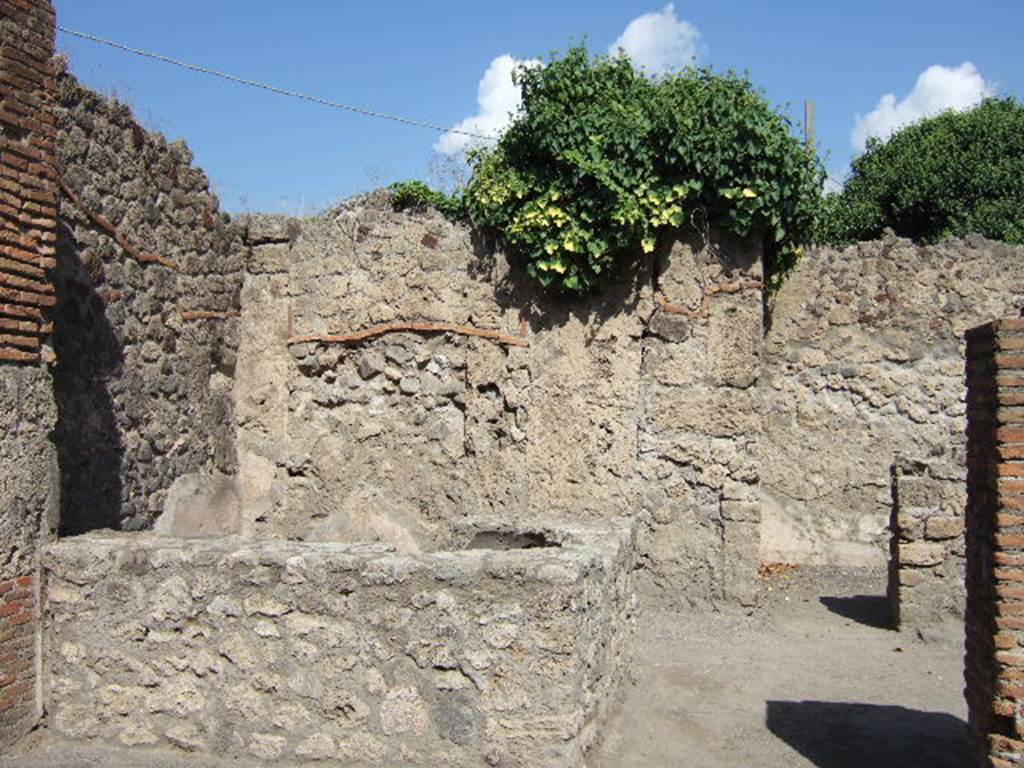 VII.7.9 Pompeii. September 2004. Looking north across bar. On the left the two-sided bar podium, on the right a doorway to a rear room.
