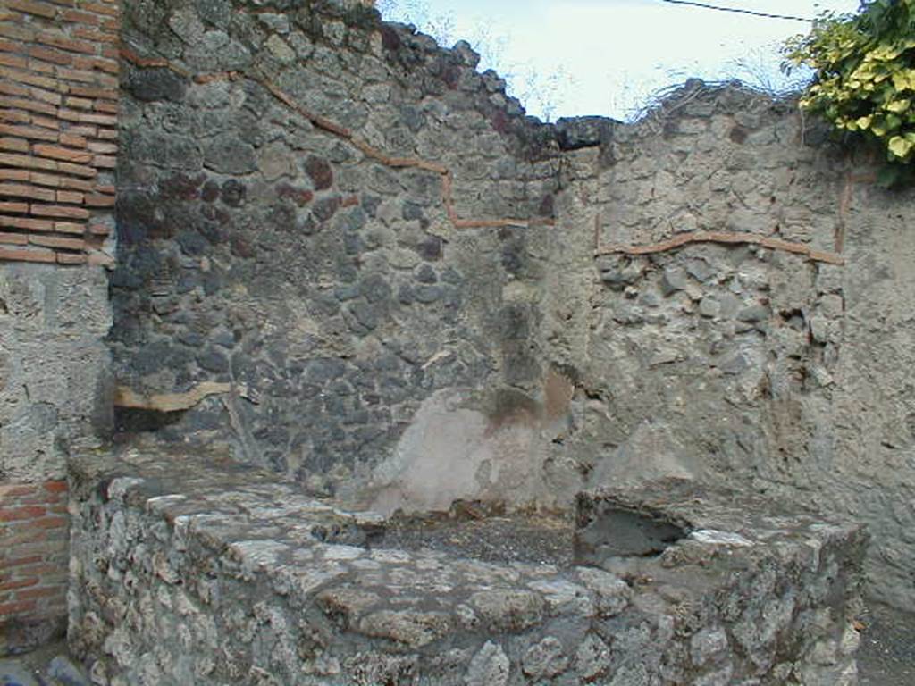 VII.7.9 Pompeii. September 2005. Looking west across two-sided counter, with remains of two urns.