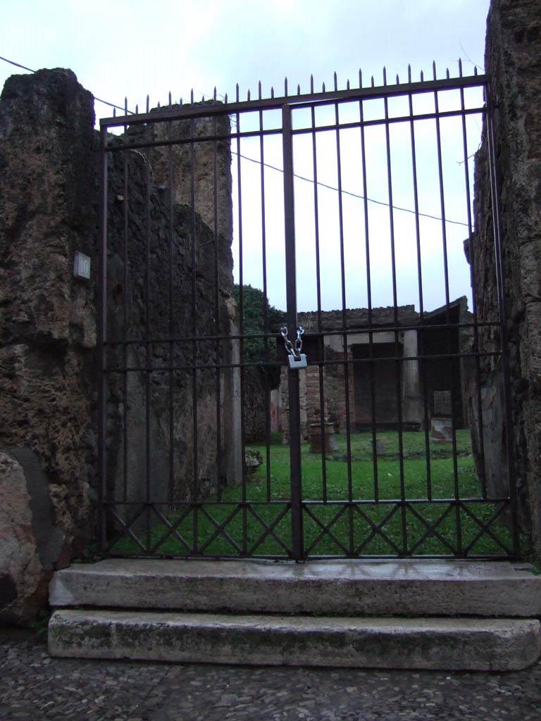 VII.7.10 Pompeii. December 2005. Entrance doorway, looking north.
According to Garcia y Garcia, this house was hit extremely hard by the bombing on the night of 24th August 1943.
It caused the partial demolition of the atrium and its room on the east, as well as the room to the west of the tablinum comprising part of the western perimeter wall.
Also destroyed were two big pilasters on the east side of the peristyle, three rooms on the north-east side of this, and part of the northern perimeter wall.
A second bomb hit the area near the rear exit at VII.7.13 during the night of 13th September 1943.
Due to these repeated assaults, nearly all the paintings of the fourth style fell and perished.
In an oecus, the painting described as the birth of Rome showing the wolf with the twins Romulus and Remus was lost. This painting gave the name to the house.
See Garcia y Garcia, L., 2006. Danni di guerra a Pompei. Rome: L’Erma di Bretschneider. (p.115-116).
