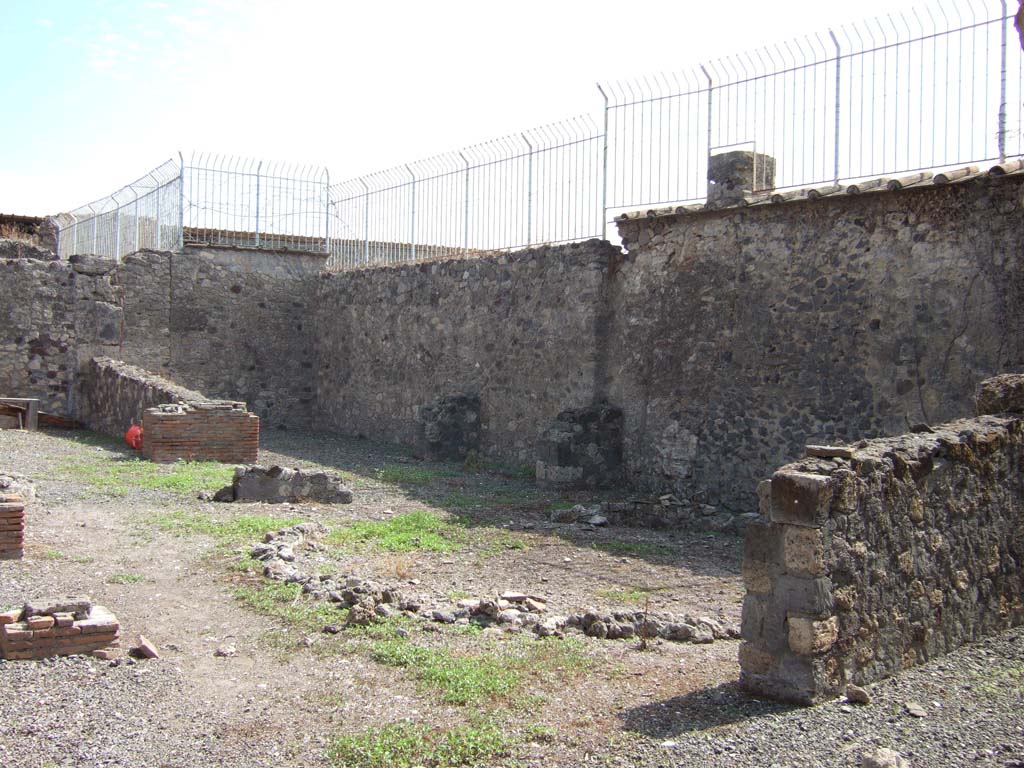 VII.7.16 Pompeii. September 2005. South side of peristyle garden. 
According to Jashemski, the peristyle garden was originally enclosed by a portico on the west, north and east.
A passageway led directly from the Vicolo del Gallo into the portico of this house without an atrium. 
The circular area with remains of a wall was an aviary.  
See Jashemski, W. F., 1993. The Gardens of Pompeii, Volume II: Appendices. New York: Caratzas. (p.188 and Fig. 221).
