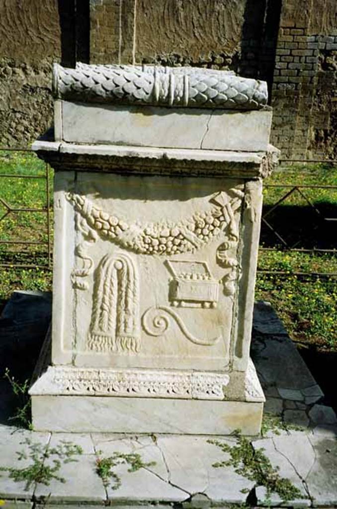 VII.9.2 Pompeii.  July 2010. Altar. South side. According to Mau, the north and south sides have representations of ceremonial objects used in sacrificing. On this side is the napkin (mantele), the augural staff (lituus), and the box in which the incense was kept (acerra). See Mau, A., 1907, translated by Kelsey F. W. Pompeii: Its Life and Art. New York: Macmillan. (Page 107). Photo courtesy of Rick Bauer.