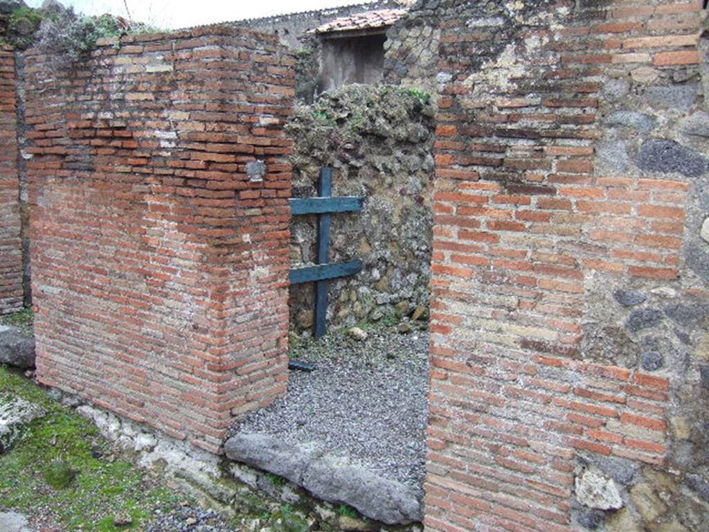 VII.9.31 Pompeii. December 2005. Entrance doorway on west side of Vicolo di Eumachia. 
According to Fiorelli �
VII.9.29-31.
Con due altre botteghe, che costituivano un termopolio termina questa lato dell�isola. La prima ha la scaletta, ed una cella dietroposta: la seconda oltre il banco di fabbrica co�rispondenti scalini, per tenervi sopra bicchieri e stoviglie, ha una seconda gradinata, una della piu interna con focolare ed uscita nei vico ad oriente, e l�adito di una scala portante a stanze superiori. Poco discosto leggesi �
C. LOLLIVM.FVSCVM.AED. 
(trans: This side of the insula ended with two other shops, which constituted a thermopolium. The first had the stair-ladder, and a room behind it: the second apart from the masonry bench with corresponding steps/shelves, to keep glasses and dishes on top, had a second stairs, one of the rooms most internal with hearth and exit onto the eastern vicolo, and the entrance doorway to a staircase leading to the upper rooms. Nearby was read �
C. LOLLIUM.FUSCUM.AED.)
See Pappalardo, U., 2001. La Descrizione di Pompei per Giuseppe Fiorelli (1875). Napoli: Massa Editore. (p.106).
