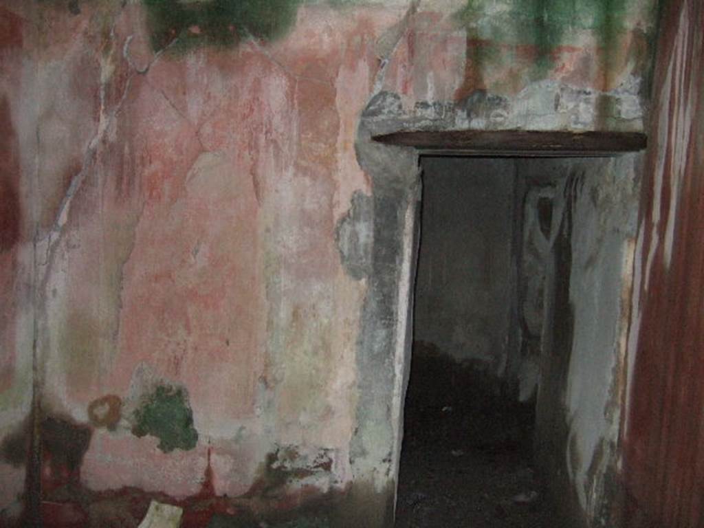 VII.10.3 Pompeii. December 2005. Room 15, looking east into room 16. The doorway to room 14 is on the far right in room 16. According to Breton, this was a well-decorated area, with a doorway from the peristyle, as well as one from the exedra, room 14. 
According to Amoroso, this was repainted with new IVth style decorations.
The red zoccolo was divided into small partitions by black cornices and borders of yellow connected by small garlands. In the centre was a painted stylized griffin.  The middle zone showed two red panels with black borders, separated by a yellow strip with architectural paintings, at the base of which was a predella edged with a red cornice in which a panther could be seen.  The second room, room 16, also had new IVth style decoration with black zoccolo, on which were painted vertical squares painted in white and yellow. 
Studi della Soprintendenza archeologica di Pompei, 22: l”Insula VII, 10 di Pompei, by Angelo Amoroso, (p.77) 
