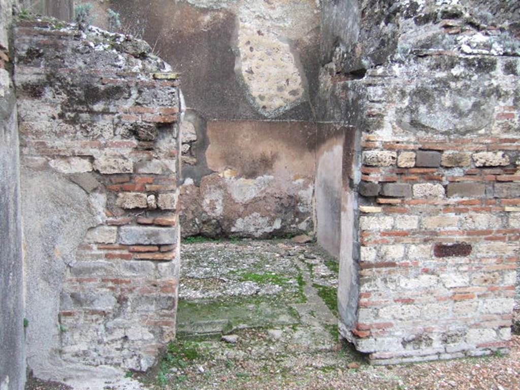 VII.10.5 Pompeii. December 2005. Doorway to cubiculum in north-west corner of atrium.
According to Amoroso, in the surface of the floor of this room and preserved in situ is the only shaped tufa of Nocera block, belonging to the previous impluvium. (p.80)
Studi della Soprintendenza archeologica di Pompei, 22: l”Insula VII, 10 di Pompei , by Angelo Amoroso. (p.80)
According to Bragantini et al, the flooring in this room was cocciopesto with scattered chippings of black and white tesserae. The plastered walls had a high protruding zoccolo of cocciopesto, the middle zone was still rough plaster.
See Bragantini, de Vos, Badoni, 1986. Pitture e Pavimenti di Pompei, Parte 3. Rome: ICCD. (p.182)