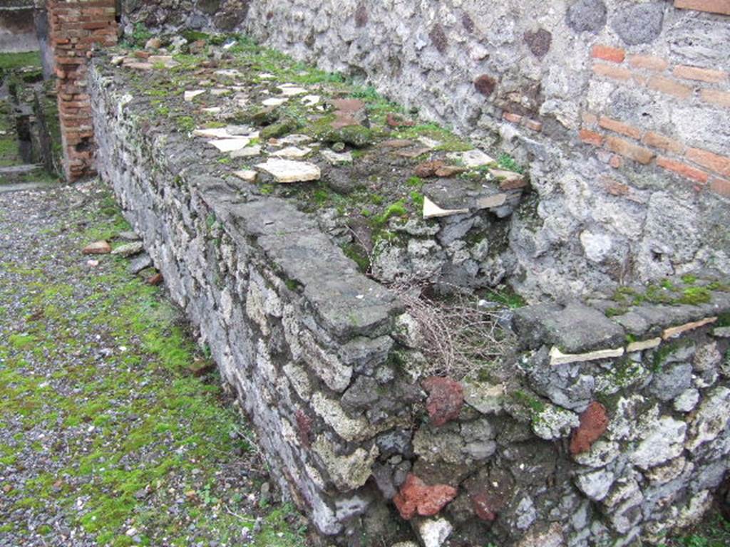 VII.10.5 Pompeii. December 2005. Podium and tub for heating a vat, against south wall of peristyle. According to Amoroso, the installation of the workshop (“officina lanifricaria”) determined the transformation of the peristyle, whose south side was filled with counters and by basins set in masonry. The ample portico space was transformed from a walkway to represent a working courtyard, and probably given a gallery, which was accessed by a ramp located in an alcove described by Fiorelli.
Studi della Soprintendenza archeologica di Pompei, 22: l”Insula VII, 10 di Pompei , by Angelo Amoroso. (p.80)
