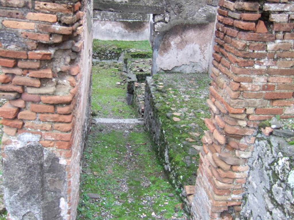 VII.10.5 Pompeii. December 2005. Looking east in rooms leading towards rear entrance doorway at VII.10.13. According to Amoroso, at the rear of the house, kettles and tubs were installed in a masonry bench. This would seem to indicate that the use of the area was changed perhaps into an “officina lanifricaria”.