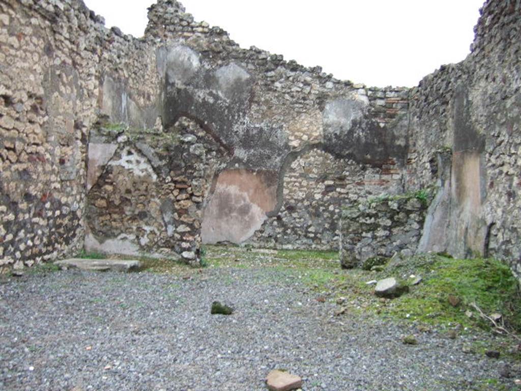 VII.10.6 Pompeii. December 2005. Looking east across shop towards doorway to rear room.
In the north-east corner of the shop-room (on left) can be seen the remains of the base of steps to upper floor.
According to Amoroso, the floor of the shop was simple cocciopesto, whereas the rear room�s floor was the same flooring made with scattered polychrome pieces, similar to the adjacent atrium (of VII.10.5), of which this room had once been part. The walls of the two rooms were plastered with plaster without colour.
Studi della Soprintendenza archeologica di Pompei, 22: l�Insula VII, 10 di Pompei , by Angelo Amoroso. (p.69)

