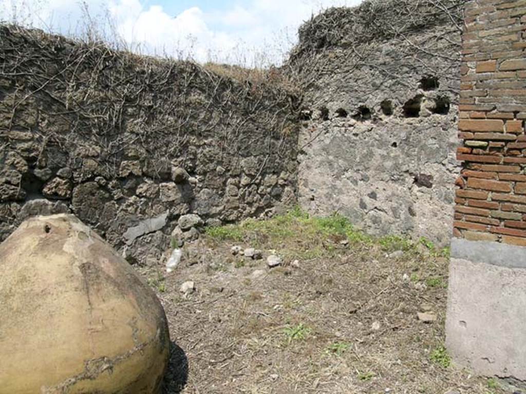 VII.12.10 Pompeii. June 2005. Rear yard with dolium, and small room with holes in wall for support beams for a roof, this may have been the latrine. Photo courtesy of Nicolas Monteix.
