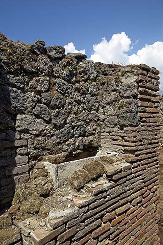 Fig. 50 � Pomp�i, boulangerie VII 12, 11 � Chauffe-eau incorpor� dans le mur diaphragme du four dans une seconde phase.
On note que la fa�ade initiale (� gauche) �tait construite en tuiles (vue du sud-est).
Clich� : F. Pauvarel � EFR.
