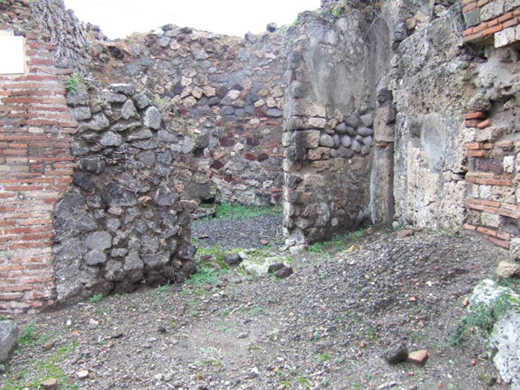 VII.12.25 Pompeii, at front, door to VII.12.26 centre and blocked door at VII.12.24 on right. December 2005.