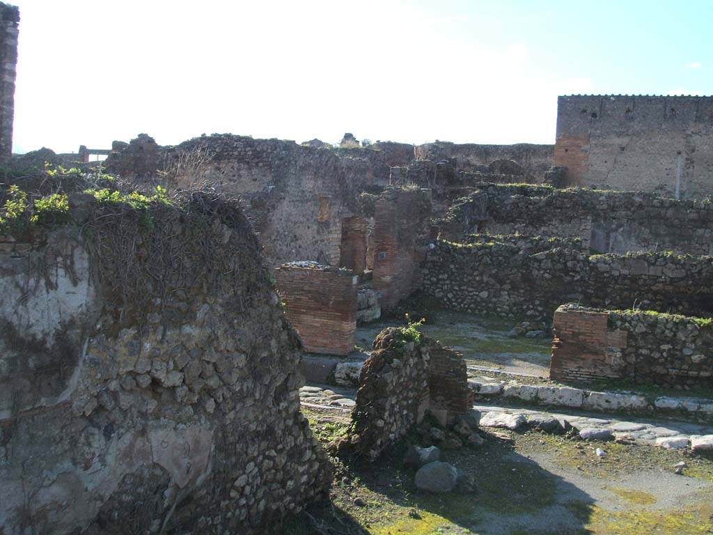 VII.12.35 Pompeii. December 2004. Looking west onto Vicolo di Eumachia. VII.12.35 in foreground with doorway to VII.12.34., in centre