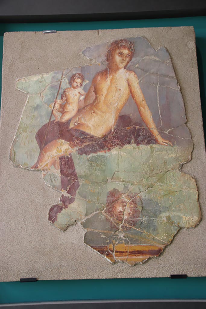 VII.15.2 Pompeii. October 2022.
Painting of Narcissus and Eros from the tablinum, found in pieces and restored.
Photo courtesy of Klaus Heese, photographed at an exhibition in the Palaestra.