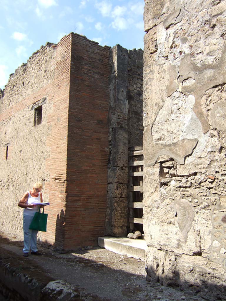 VII.15.2 Pompeii. September 2005. Entrance.
On the west side (left) of the entrance a painted graffito was found: 
(C. Lollius?) Fuscus cupidus fecit   [CIL IV 3582]
On one of the side walls of this vestibule, two other painted graffiti were found:
Fuscus cupidus fecit  [CIL IV 3583] and [Fuscus] cupidus rog(at)  [CIL IV 3585].
See Della Corte, M., 1965. Case ed Abitanti di Pompei. Napoli: Fausto Fiorentino. (p.199)

According to Epigraphik-Datenbank Clauss/Slaby (See www.manfredclauss.de), these read –

Kapella(m) IIvir(um)
IIvir(um) Cupidus
Fuscus fecit       [CIL IV 3582]

Paquium d(uum)vi(rum)
Fuscus Cupidus
fecit       [CIL IV 3583]

P(ublium) P(aquium) P(roculum) et C[3]
Cupidus
rog(at)       [CIL IV 3585]

