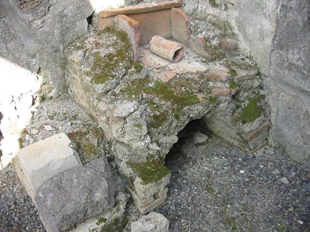 VII.15.4 Pompeii. May 2003. Bench of the oven with tiled top and arched recess beneath, in south-east corner of kitchen. Photo courtesy of Nicolas Monteix.
