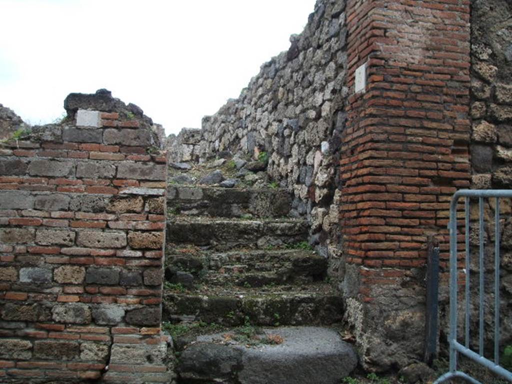 VII.16.5 Pompeii. December 2004. Steps to upper floor, looking north.
Originally, under these stairs would have been a small storeroom or cupboard with a doorway in the west wall of VII.16.6.
See Eschebach, L., 1993. Geb�udeverzeichnis und Stadtplan der antiken Stadt Pompeji. K�ln: B�hlau. (p.347)
 