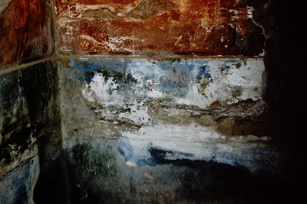VIII.2.18 Pompeii. 1961. Frigidarium 54, the plunge pool on level 4, detail of remains of west end of north wall.
In the upper right is one of the pediment feet shown in the 1896 Niccolini painting.
The blueish band in the middle is the western half of the landscape panel.
Photo by Stanley A. Jashemski.
Source: The Wilhelmina and Stanley A. Jashemski archive in the University of Maryland Library, Special Collections (See collection page) and made available under the Creative Commons Attribution-Non-Commercial License v.4. See Licence and use details. 
J61f0805
