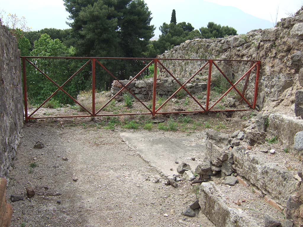 VIII.2.34 Pompeii. May 2006. Looking south through doorway of room ‘o’ with stairs to upper floor, on right.
The floor was formed of a white mosaic with black border, in the centre of which was the emblema showing a lion and leopard, below.
