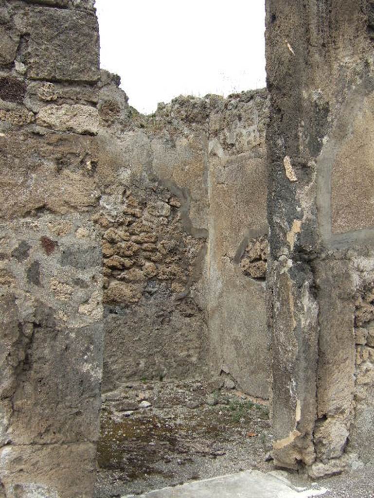 VIII.2.34 Pompeii. May 2006. Looking north-west through doorway of cubiculum ‘k’ on west side of atrium ‘c’. The flooring found in this room was of cocciopesto with a net of meandering swastikas, alternating with squares with a white central cross. When excavated, only a fragment of black zoccolo was found on the east wall.
