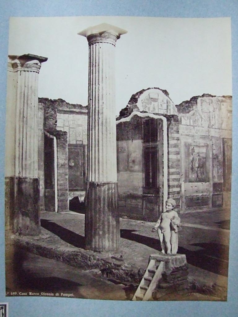 VIII.4.4 Pompeii. Fountain and south portico of peristyle. Old undated photograph number 489.
Courtesy of Society of Antiquaries, Fox Collection.
According to Dyer:
“Two of the rooms on the further side of the peristyle, and at the extremity of the house, are visible in this view.
The smaller one, on the left, appears to be a bedchamber.
The floor is of opus Signinum; the walls painted mostly red and yellow, apart from the usual architectural ornaments, also have pictures of Nereids riding through the waves on sea-monsters.
The picture facing the entrance, so far as can be made out, represented the Dioscuri.
Next to this room, on the right, is a large and handsome exedra, or retiring room.
It is paved with black and white marble and has in its middle a small impluvium or basin; from which we may infer that there was a corresponding aperture in the roof.
The walls were adorned with small but well-executed pictures.
On the facing wall was Narcissus admiring himself in the fountain.
On the left wall a Hermaphrodite leaning on the shoulder of Silenus could be seen.
On the right wall, Bacchus accompanied by his usual troop, discovering Ariadne. 
See Dyer, Thomas, 1867: The Ruins of Pompeii. London: Bell and Daldy, (p.80).
