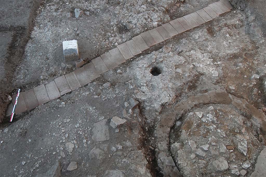 Fig. 17 � Pomp�i, boulangerie VIII 4, 26-27 � Moiti� m�ridionale de la salle des meules. 
L�alignement de briques correspond au passage d�un c�ble �lectrique ; au sud-est de la salle, la fosse septique avant le d�but du d�gagement de son remplissage.
Pris du sud. Clich� : S. Zanella /EFR.
