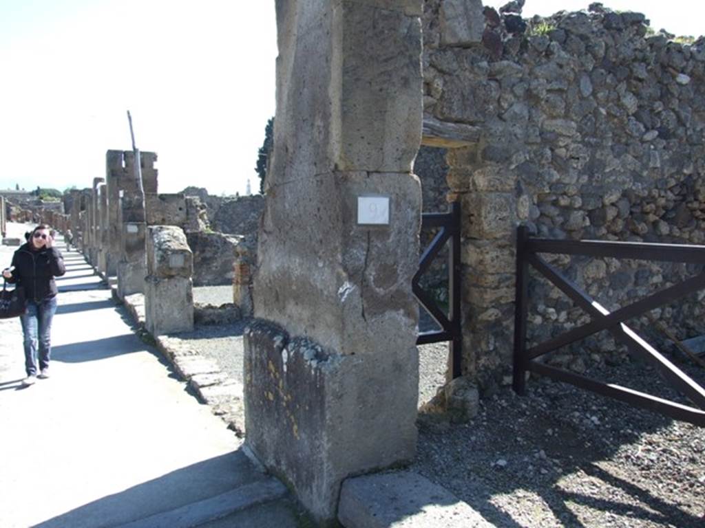 VIII.5.9 Pompeii. March 2009. East side of entrance fauces on Via dell�Abbondanza, with puteal for a well in small doorway to shop at VIII.5.10
According to Maiuri, 
�This house also opened onto the south side of the Via dell�Abbondanza, with a doorway in tufo between two shops; it had a short but wide entrance corridor with undecorated walls in large part restored after the earthquake; a stone threshold was on the external side of the doorway and one of travertine on the interior between the corridor and the atrium; a puteal for a well was embedded in the left wall, where it would have been used above all by the neighbouring shop (another puteal was inserted in the dividing wall between the shops numbered 10 and 11.�
see Maiuri in Notizie degli Scavi, 1944-45, (p.154). 
shop at VIII.5.10