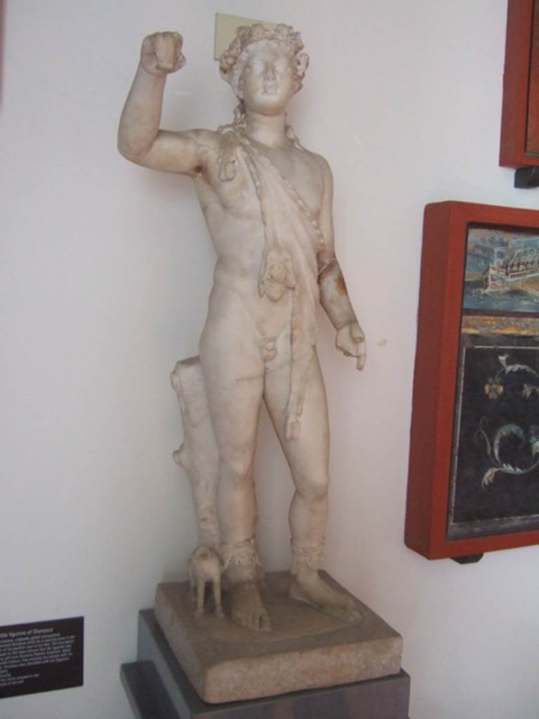 VIII.7.28 Pompeii. Statue of Bacchus (Dionysus) with his panther.  The inscription engraved on the base informs us that the figure was a votive gift from Numerio Popidio Ampliato, father of Popidio Celsino, that restored the Temple with his money.  Claudian. From the niche in the back wall of the temple Cella.   Dionysus was identified with the Egyptian god Osiris. Now in Naples Archaeological Museum.
