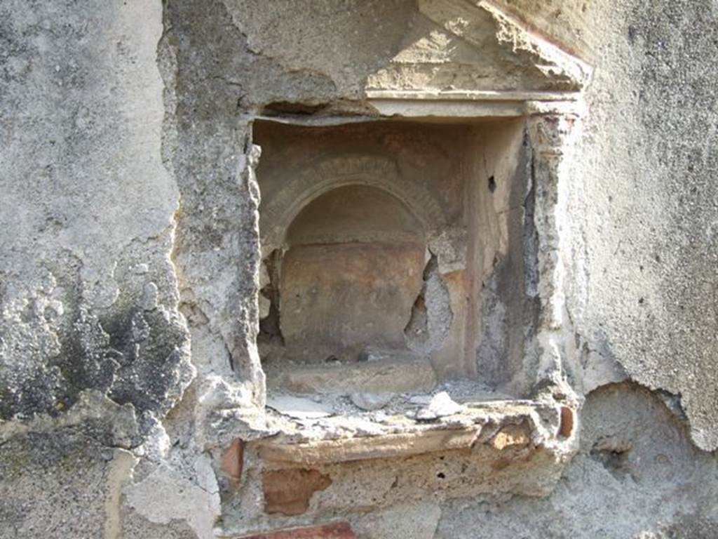 IX.2.21 Pompeii. March 2009. Room 11, south wall with aedicula shrine, and remains of stucco interior. Boyce said below the niche was a heavy ledge, richly adorned with complex triple frieze of various designs of polychrome modelled stucco. Upon it rested the bases of applied half-columns with capitals that supported the pedestal. All three cornices surrounding the tympanum were decorated with stucco friezes. The whole fa�ade was decorated with red stripes against the white stucco background.
