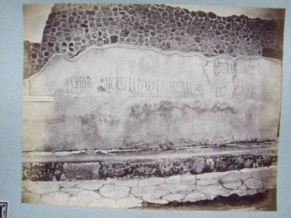 IX.3.19 Taberna T. Genialis. Graffiti on wall between IX.3.18 and IX.3.19.
Old undated photograph courtesy of the Society of Antiquaries, Fox Collection.

According to Fiorelli, the wall that preceded this shop had varied and important graffiti.
Some of them read:

M . C . M . AED . M . S . M AED
PYRAMVS . OLYMPIONICA
CALVOS . ROG  OVF

M. CASELLIVM . ET . L . ALBVCIVM . AED . OVF
STATIA . ET . PETRONIA . ROG . TALES . CIVES . IN . COLONIA . IN . PERPETVO

L . ALBVCIVM . CELSVM . AED
T. GENIALIS . INFANTIO . ROG

See Pappalardo, U., 2001. La Descrizione di Pompei per Giuseppe Fiorelli (1875). Napoli: Massa Editore. (p.146-7)

According to Epigraphik-Datenbank Clauss/Slaby (See www.manfredclauss.de) these read

M(arcum) C(asellium) M(arcellum) aed(ilem) M(arcum) S() M() aed(ilem) / 
Pyramus Olympionica 
Calvos rog(ant)
o(ramus) v(os) f(aciatis)      [CIL IV 3674]

M(arcum) Casellium et L(ucium) Albucium aed(iles) o(ro) v(os) f(aciatis)
Statia et Petronia rog(ant) tales cives in colonia in perpetuo      [CIL IV 3678]

L(ucium) Albucium Celsum aed(ilem)
T(itus) Genialis Infantio rog(at)      [CIL IV 3680]

According to Della Corte, he thought people working or living here were named on the surviving electoral propaganda.
3 men named as Pyramus, Calvus, and T. Genialis, with the writer being Infantio, and 3 women named as Statia, Petronia and Olympionica.
These three were found on the left of the entrance doorway, between IX.3.18 and IX.3.19:
See Della Corte, M., 1965.  Case ed Abitanti di Pompei. Napoli: Fausto Fiorentino. (p. 193)

