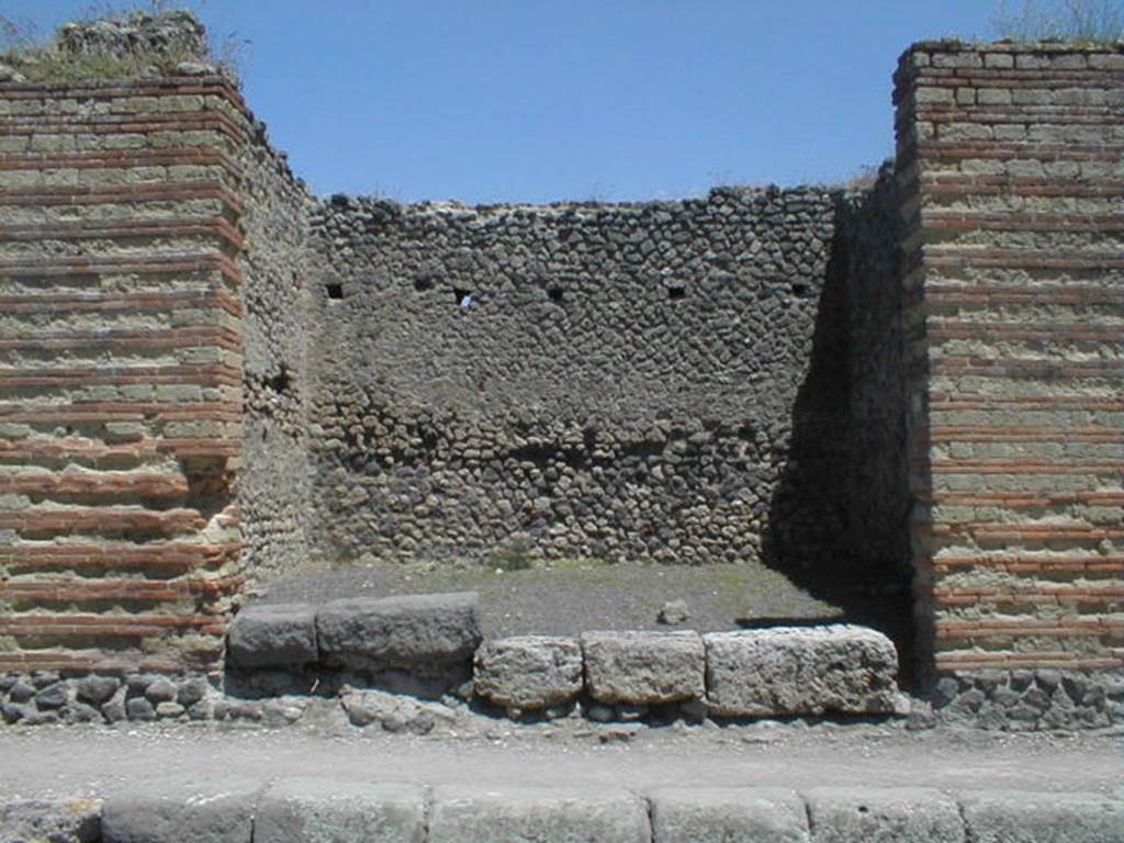 IX.4.3 Pompeii. May 2005. Entrance.
According to Maiuri, three of the shops on the corner of this insula, appear to have had an elevated threshold of at least 0.80m above the floor of the sidewalk and what should have been the original threshold. They clearly distinguish the brickwork/masonry of the above elevation from the original floor of the threshold. In the third taberna (from the corner of the quadrivium) IX.4.3, only one block of the threshold appears located in its place.
See Maiuri, A, (2002): L�ultima fase edilizia di Pompei, Arte Tipografica, Naples, (p.75, note 3).
