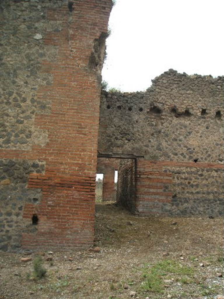 IX.4.16 Pompeii. May 2005. Looking west from entrance across the open area �u�, described by Mau, towards the corridor leading into the area �i� which may have been a changing room. The doorway at the far end would have led to the palaestra [d].