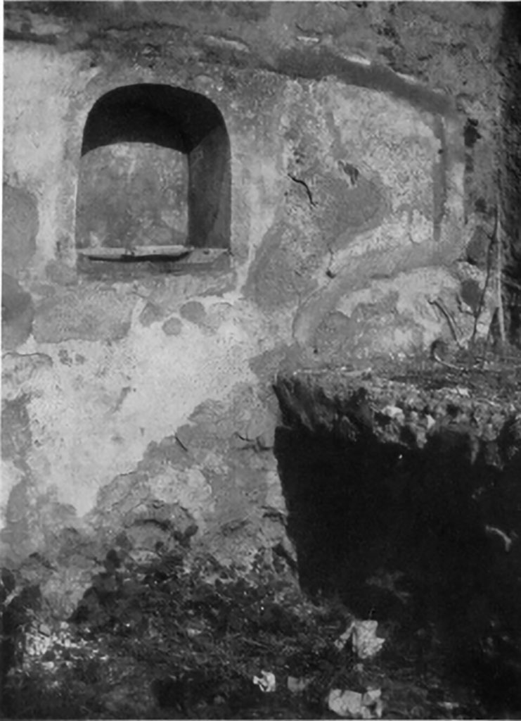 IX.5.9 Pompeii. 1930s photo by Tatiana Warscher. Room “n”, arched niche in north wall of kitchen.
According to Boyce, a burning altar was painted on the wall on each side of the niche, with a yellow serpent gliding towards it between plants and flowers.
See Boyce G. K., 1937. Corpus of the Lararia of Pompeii. Rome: MAAR 14. (p. 86, no. 423, Plate 2,4)