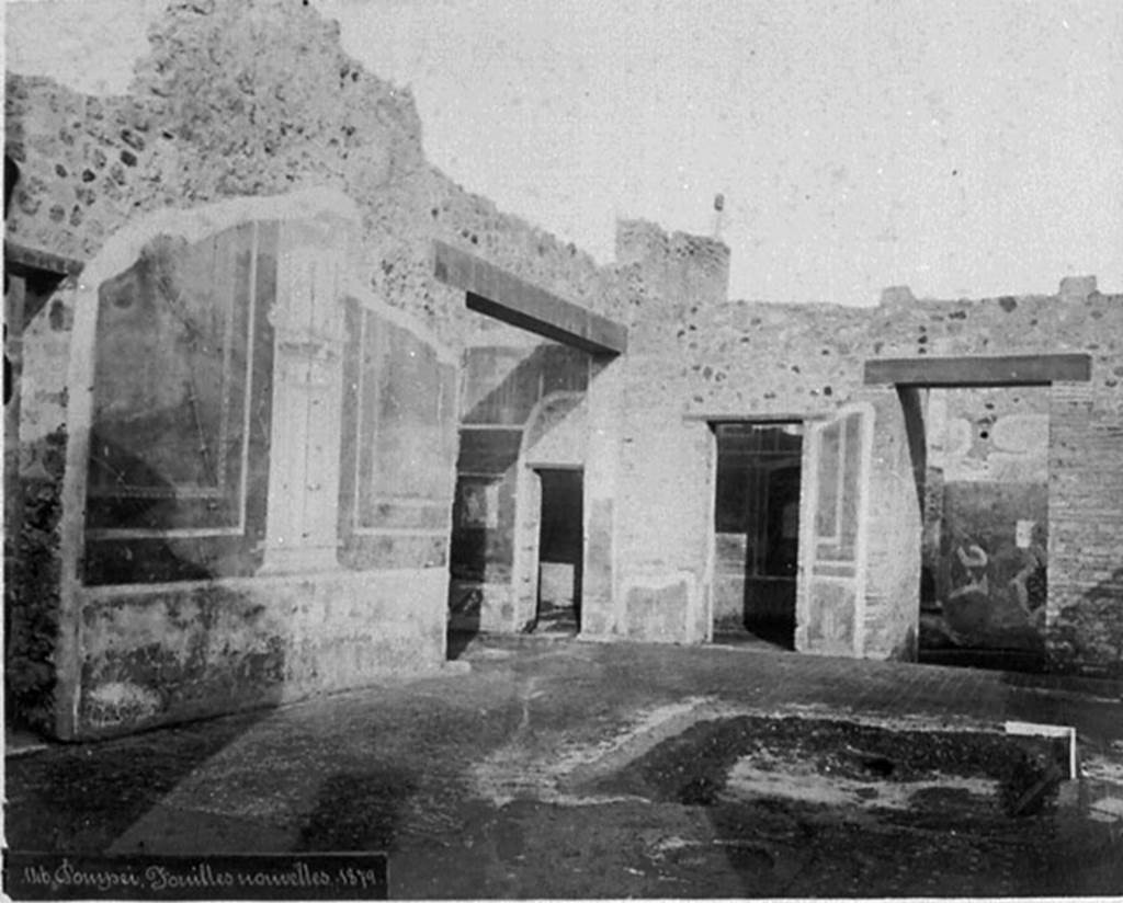 IX.5.14 Pompeii. Old photograph, c.1880.
Looking north-east across atrium, with remains of the impluvium in the floor of cocciopesto dotted with small crosses of white tesserae, with black centre.
Room �e� an ala, with doorway to room �d�, can be seen in the centre, then to its left � the doorway to room �c�, and entrance corridor �a�, on the right.

