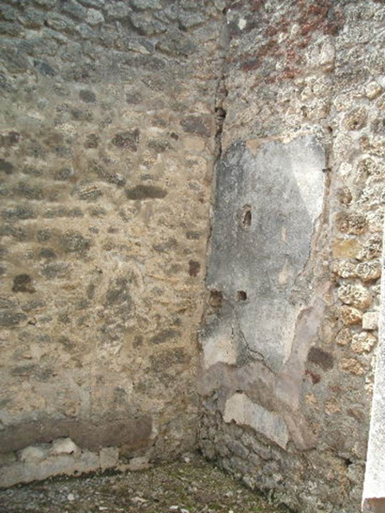 IX.6.5 Pompeii. May 2005. South-west corner of room “k” on south side of atrium. According to Mau, rooms “k” and “l” (room L) preserve remains of decoration in the I style: the remains of the walls in “k” are white, in “L” they were rough and unplastered. In the west wall of “k” one could see the holes for supporting two shelves in the remains of the white plaster.
The door threshold of lava had four rectangular hollows for the fixtures of the door, and one square hollow for the door-bolt/latch.
 See Mau, in BdI, 1880, (p.228)
