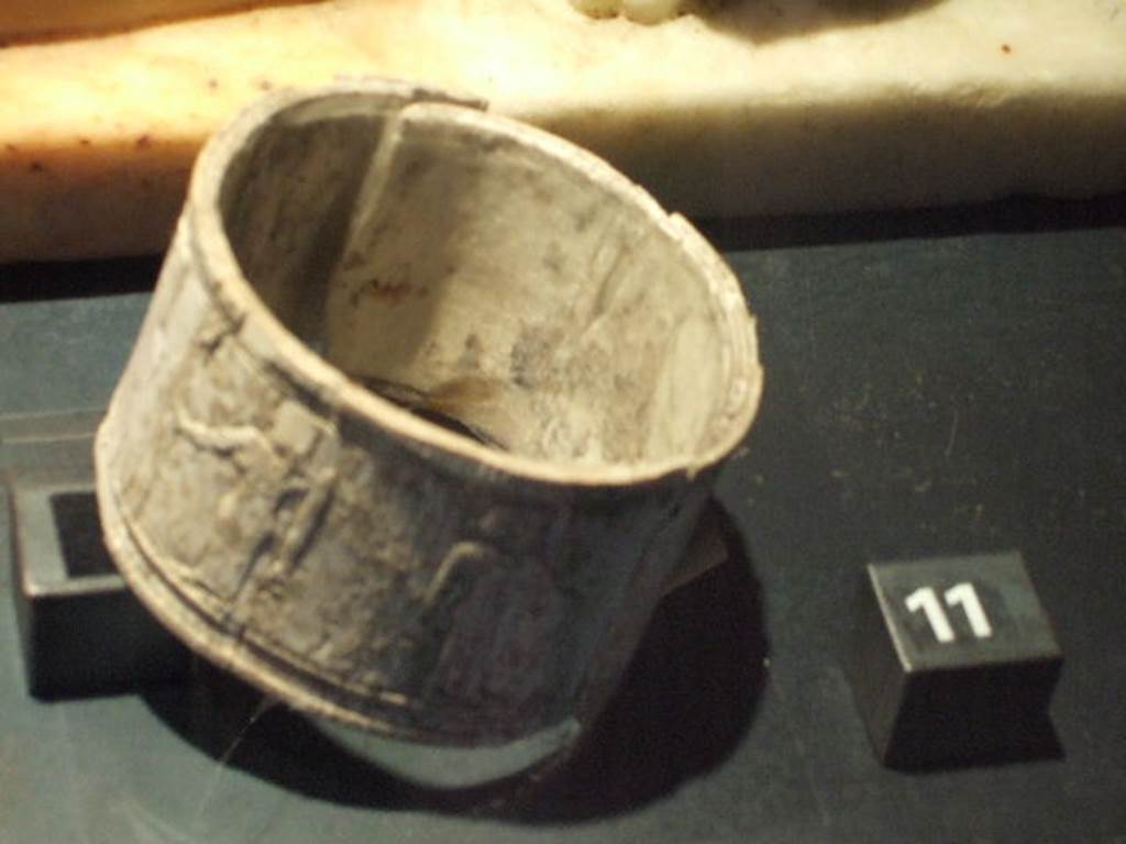 IX.6.b Pompeii. Circular ivory reliquary (pyx or pisside) decorated with relief with Egyptian figures, found in IX.6.b.  
Now in Naples Archaeological Museum.
According to Mau,
In the last (rear) room were found on 30th April 1879 other objects with special interest:
- Vases of bronze, terracotta and glass, 
- The yoke of a set of scales, 
- A strigil, etc, 
- A circular ivory reliquary, on which were seen, in low relief:
      - A seated figure with a rod, facing a crow resting on the base; 
      - Then the figure of a woman with her arm straight down, and with the left leaning, holding something in her hand that looks like a clock; 
      - Behind this is another standing figure with pole;
      - And finally a sphinx standing. 
            - All these figures are of an Egyptian type. 
            - The material of which the object is made is very fragile, and some looks as if the air will pass through it.
See Notizie degli Scavi di Antichit�, 1879, p.121.

