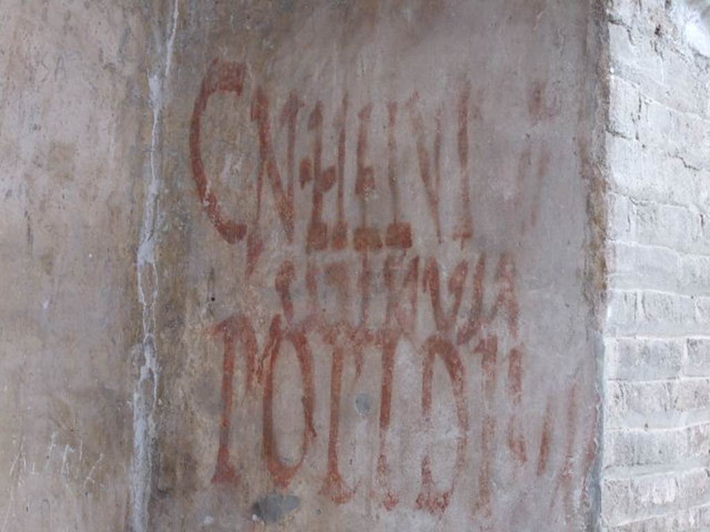 IX.7.5 Pompeii. December 2006. Graffiti outside workshop of Verecundus. According to Epigraphik-Datenbank Clauss/Slaby (See www.manfredclauss.de) CIL IV records this as two entries 
Cn(aeum)  Helvium 
Sabinum    [CIL IV 7831]

Popidium 
aed(ilem)  o(ro)  v(os)  f(aciatis)    [CIL IV 7832] 

Also see Varone, A. and Stefani, G., 2009. Titulorum Pictorum Pompeianorum, Rome: L’erma di Bretschneider. (p. 398)
