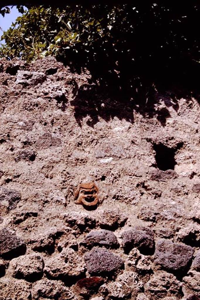 IX.7.21 Pompeii. 1964.  Exterior wall between IX/7/20 and 21, showing mask embedded in the wall.  Photo by Stanley A. Jashemski.
Source: The Wilhelmina and Stanley A. Jashemski archive in the University of Maryland Library, Special Collections (See collection page) and made available under the Creative Commons Attribution-Non Commercial License v.4. See Licence and use details. J64f1575   

