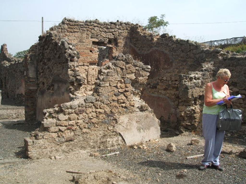 IX.7.21/22 Pompeii. May 2005. North-east corner of atrium, with doorway on left to IX.7.22, and doorway to its other room with remains of red plaster, on right.

