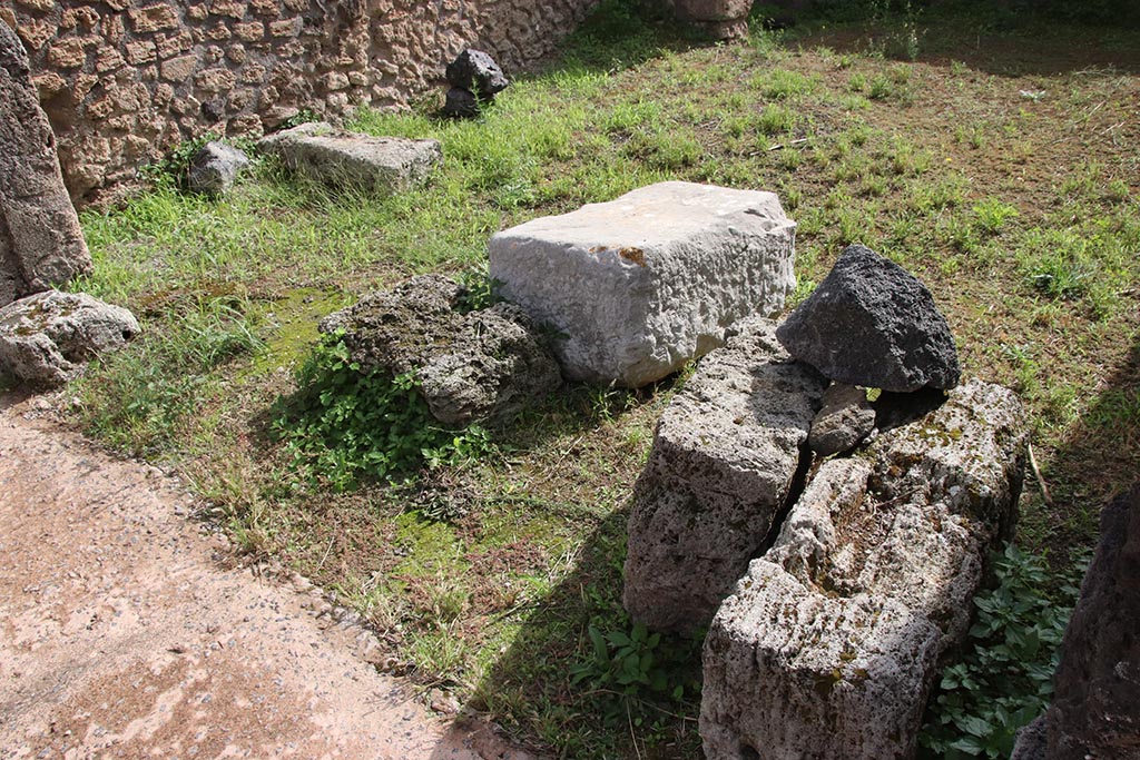 IX.7.23 Pompeii. October 2024. 
Detail of large stone block of travertine in centre of bar-room. Photo courtesy of Klaus Heese.

