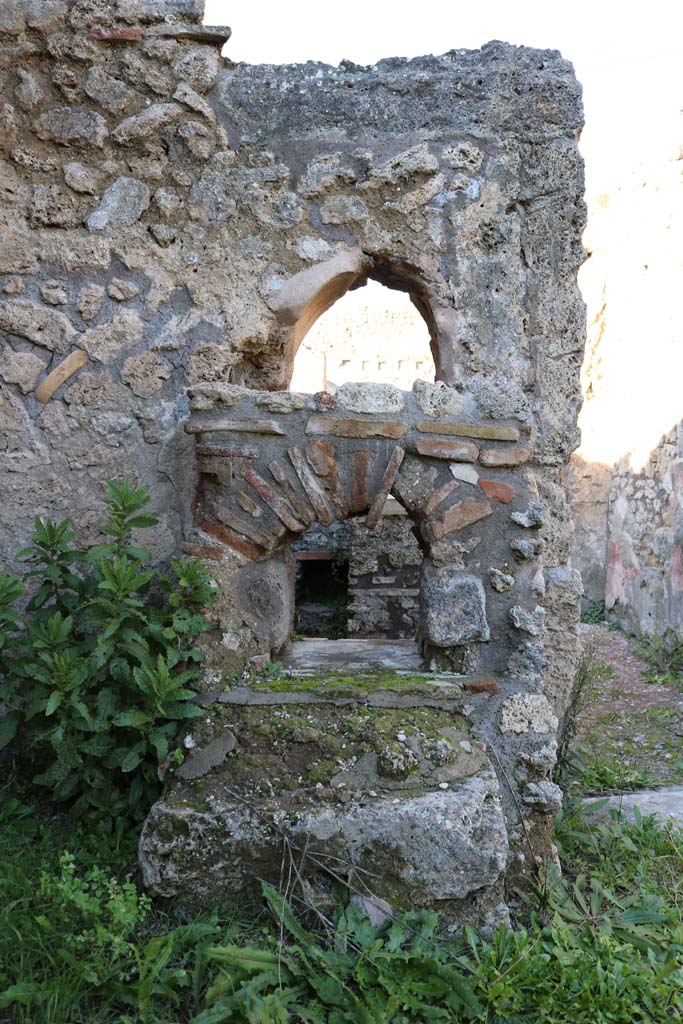 IX.7.25 Pompeii. December 2018.
Looking north into IX.7.24, from north-west corner of atrium. Photo courtesy of Aude Durand.
Below the rear of the arched niche are the remains of the hearth.