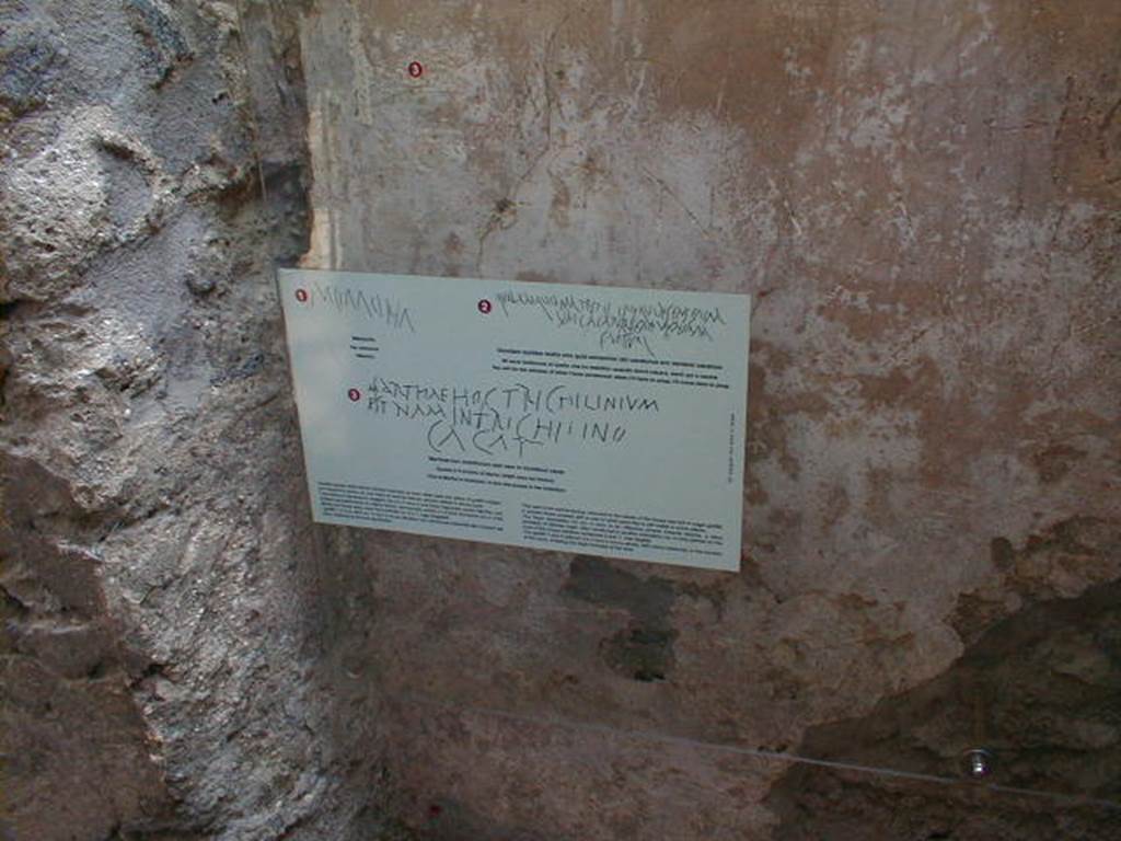 IX.8.6 Pompeii. September 2004. Room 27, scratched graffito in plaster on east wall.
Above the printed card (small red numbered 3) would be CIL IV 5244, which was written all across the wall (part also in photo below), reading:
Marthae hoc trichlinium
est nam in trichlinio
cacat - (CIL IV 5244)