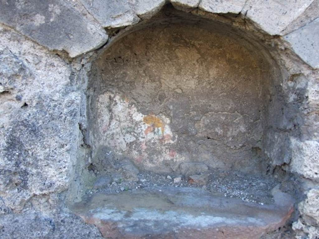IX.9.a/2 Pompeii. March 2009.
According to Boyce –
In the west wall of the peristyle is an arched niche (h.0.35, w.0.40, d.0.30, h. above floor 1.27).
The white ground of the back wall of the niche shows faint traces of a painting; in the floor is a hole for the base of a statuette.
The wall below the niche is marked off as a panel by red stripes (h.0.65, w.2.0), and in the panel is the lararium painting.
In the centre stands an altar furnished with an egg, and on the left of it is a serpent coiling amidst plants with red flowers.
On the right of the same altar is the Genius accompanied by camillus and popa.
The Genius is wreathed, wears white tunic with a vertical stripe on the left side (the right side is covered by the toga) and the toga with the broad red band which is visible in the fold which he has drawn over his head, and carries the usual cornucopia and patera; the camillus is wreathed, wears white tunic with two vertical red stripes, and carries in the left hand a shallow dish with unidentified objects represented in it, in his right hand – leaves and fillets; the popa stands farthest to the right, is also wreathed, wears a garment around the lower part of his body, and holds a sacrificial knife in his right hand, while he conducts a hog adorned with a broad red band towards the altar.
His references – Not. Scavi,1888, 515.
See Boyce G. K., 1937. Corpus of the Lararia of Pompeii. Rome: MAAR 14. (p. 90-91, no. 454)
See Giacobello, F., 2008. Larari Pompeiani: Iconografia e culto dei Lari in ambito domestico. Milano: LED Edizioni. (IX.9.2:110, p.213, no.110).