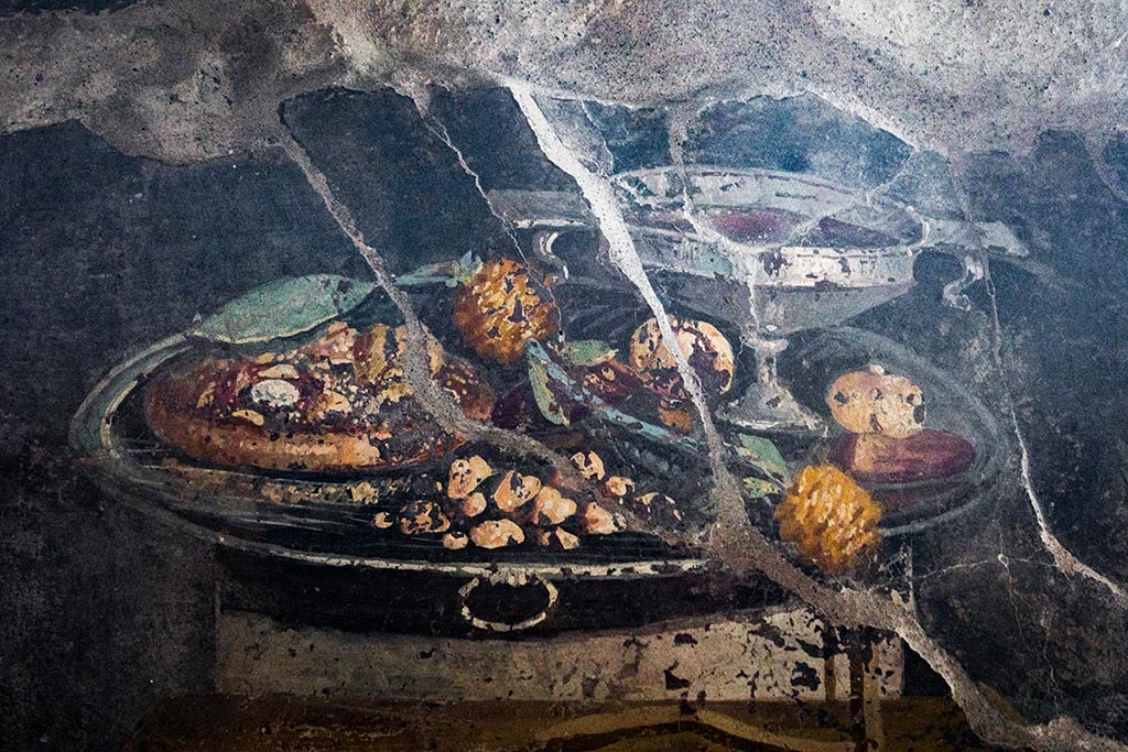 IX.10.1, Pompeii. July 2024. Atrium 2, detail of still-life in the centre of a black panel on the west wall. Photo courtesy of Johannes Eber.