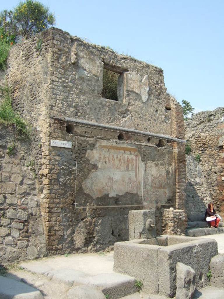 IX.11.1 Pompeii. May 2006. Front fa�ade of house on west side of entrance doorway, with steps. House with street shrine and fountain outside.
