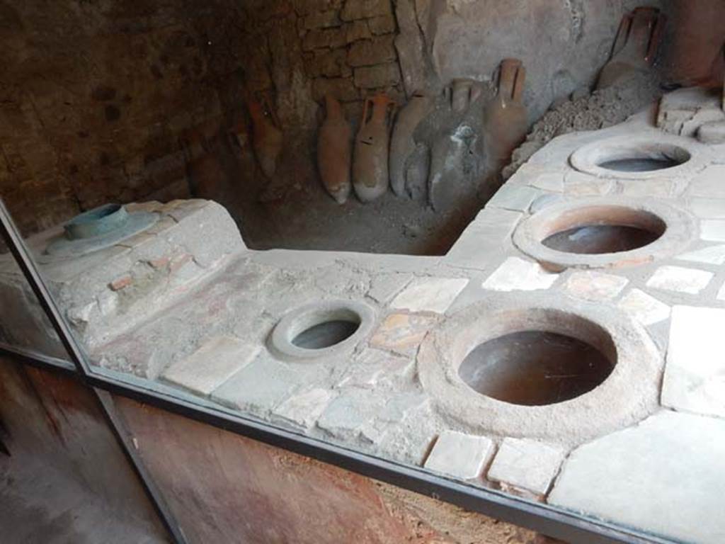 IX.11.2 Pompeii. December 2006. Looking north-east across bar counter with four dolia, and stove, on left. Photo courtesy of Buzz Ferebee.
