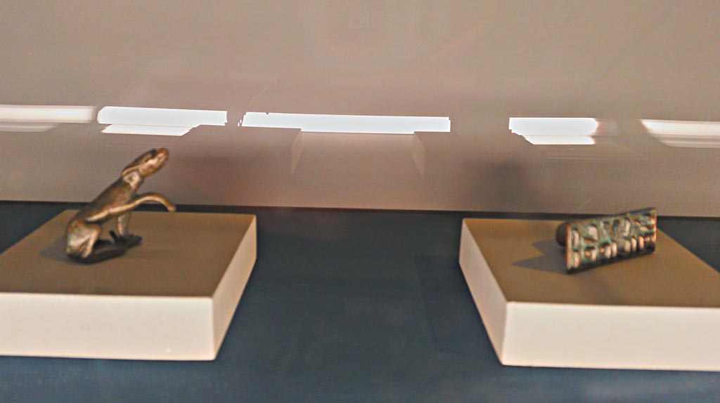 IX.13.1-3 Pompeii. December 2019. Bronze statuette of dog, and bronze seal.
Photographed at exhibition entitled “The furnishings of the House of Julius Polybius”. Photo courtesy of Giuseppe Ciaramella.